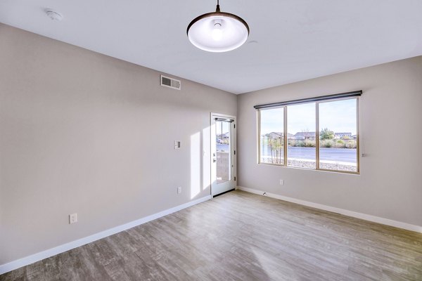 Bright living room with modern decor and large windows at The Premiere at Eastmark Apartments