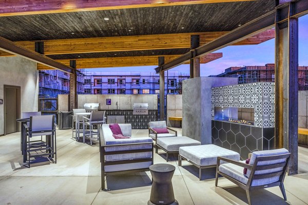 Outdoor grill area with modern patio furniture at The Premiere at Eastmark Apartments