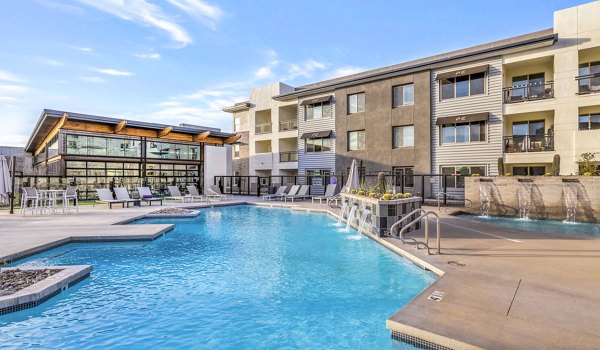 Luxury pool with sun loungers at The Premiere at Eastmark Apartments, a Greystar community