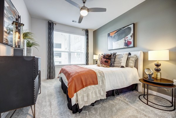 Bedroom featuring modern decor and large window at Parkside at Round Rock Apartments