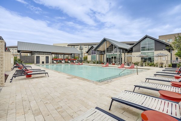 Outdoor pool at Parkside at Round Rock Apartments with lounge chairs and landscaped surround