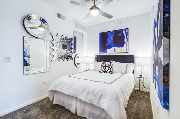 Cozy bedroom with elegant furnishings at Vineyard Apartments, featuring plush bedding and ample natural light for a comfortable living experience