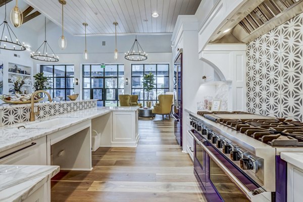 Clubhouse kitchen featuring modern appliances and island seating at Vineyard Apartments
