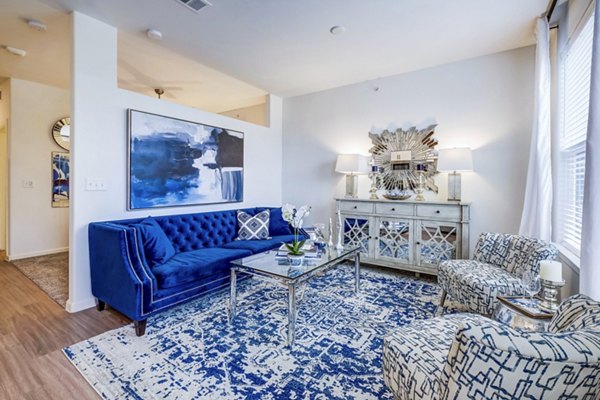 Modern living room with plush seating and large windows at Vineyard Apartments