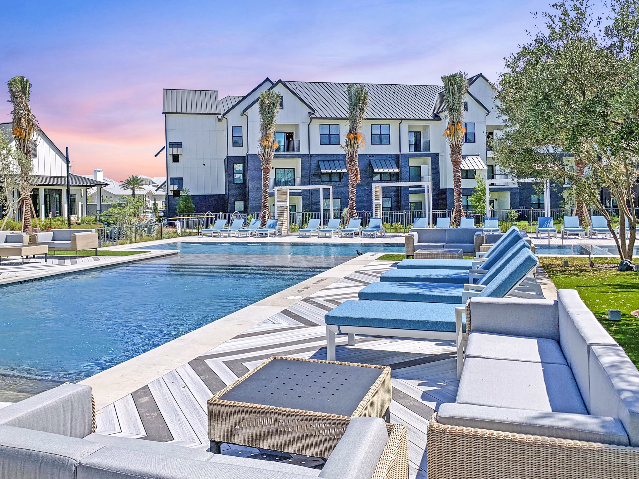 Sunlit outdoor pool at Vineyard Apartments with lush surroundings and lounge chairs