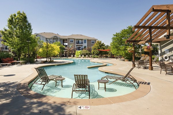 Resort-style pool with landscaped surroundings at The Trails at Timberline Apartments