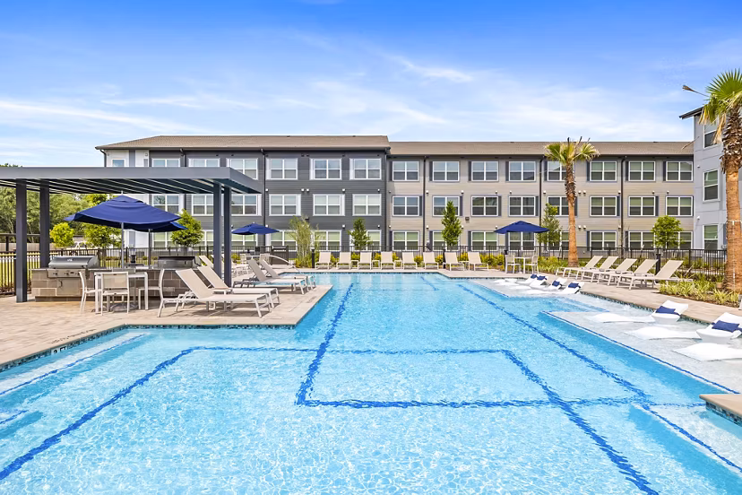 Modern pool area at Ltd Med Center Apartments with loungers and lush landscaping, perfect for relaxation and leisure