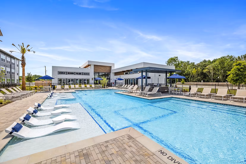 Luxurious pool at Ltd Med Center Apartments with resort-style seating and lush landscaping