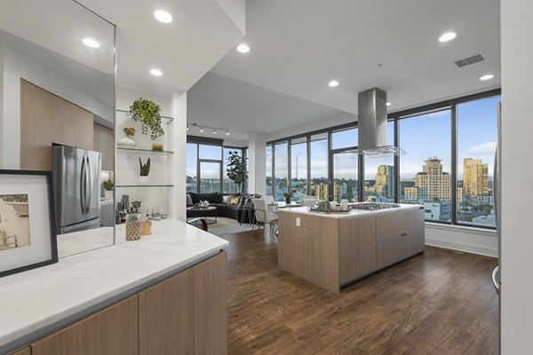 Modern kitchen with stainless steel appliances and island at Stanza Little Italy Apartments