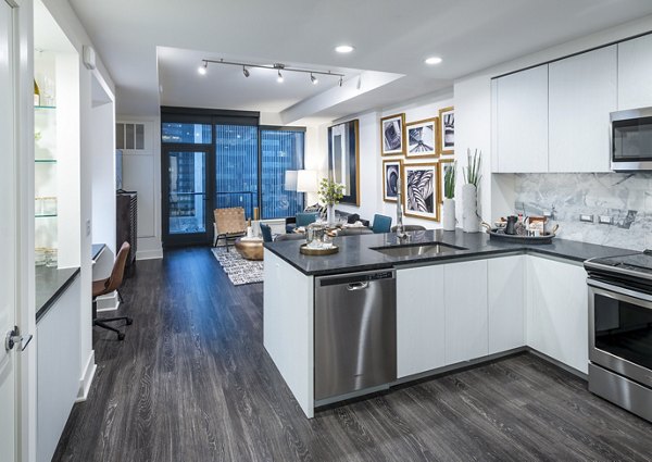 Modern kitchen with stainless steel appliances and granite countertops at Stanza Little Italy Apartments