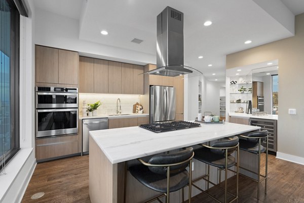 Modern kitchen featuring stainless steel appliances and quartz countertops at Stanza Little Italy Apartments in San Diego