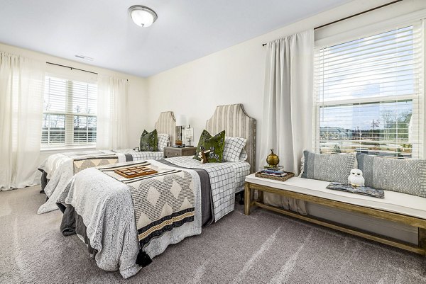 Bedroom with modern decor and ample natural light at ABODE at Parkside Apartment Townhomes