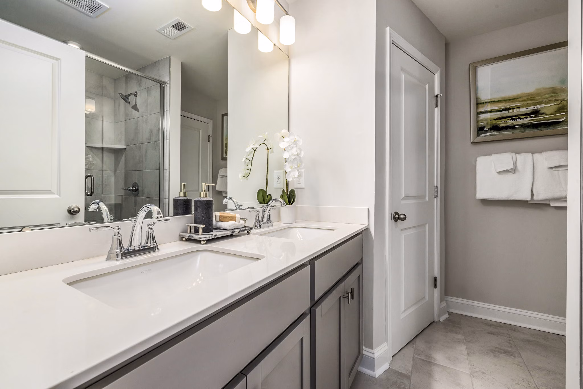 Modern bathroom featuring marble counters and sleek fixtures at ABODE at Parkside Apartment Townhomes