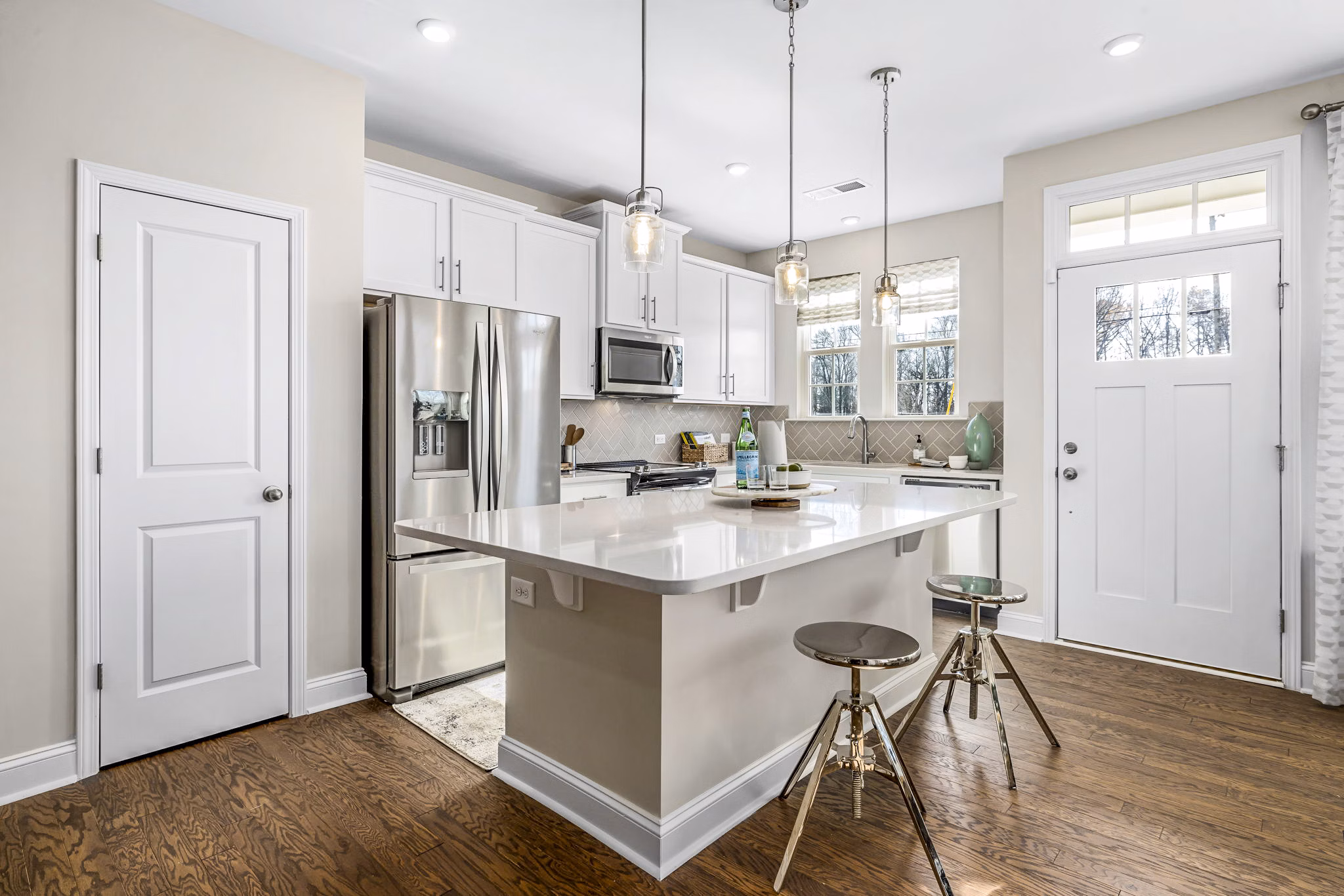 Modern kitchen featuring stainless steel appliances and granite countertops in ABODE at Parkside Apartment Townhomes