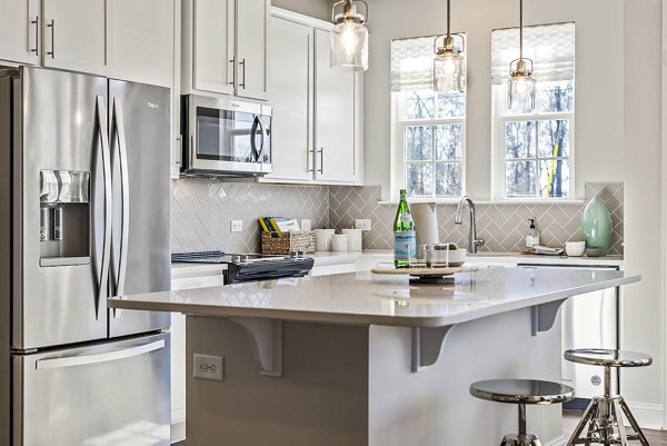 Modern kitchen with stainless steel appliances in ABODE at Parkside Apartment Townhomes