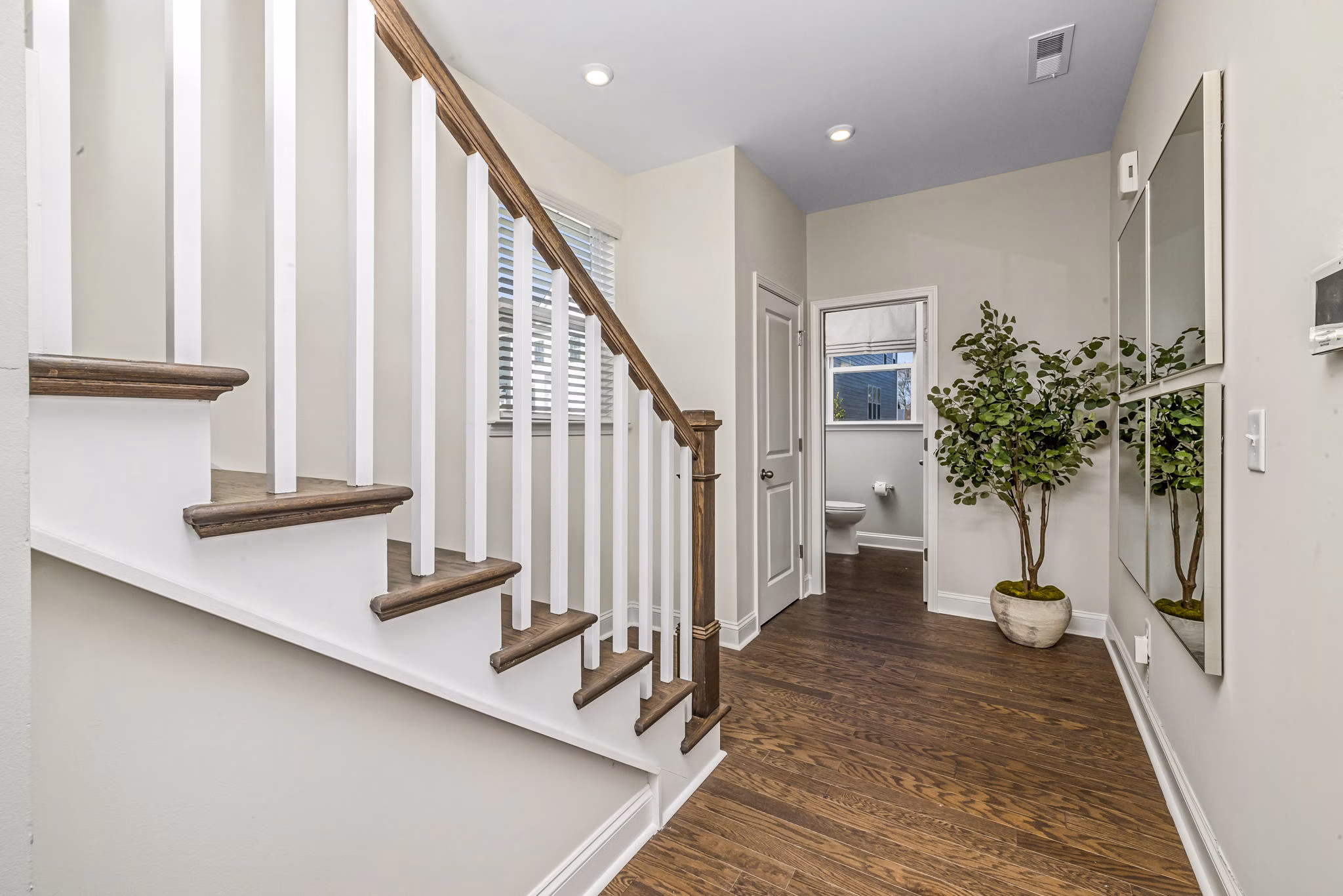 Elegant bathroom with sleek fixtures and stairway at ABODE at Parkside Apartment Townhomes