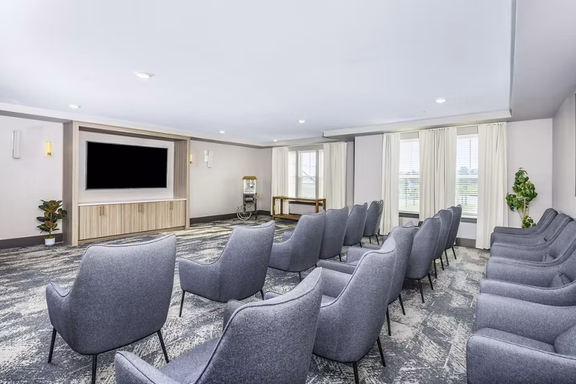 Clubhouse theater with plush seating at The Grove at Coastal Grand Apartments