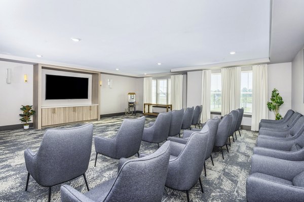 Clubhouse theater with plush seating at The Grove at Coastal Grand Apartments