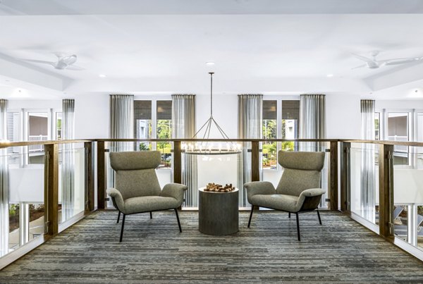 The Grove at Coastal Grand: Elegant clubhouse lobby with modern furnishings and ambient lighting in luxury apartments near shopping and dining