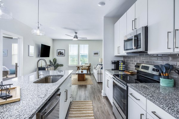 Modern kitchen with stainless steel appliances at The Grove at Coastal Grand Apartments