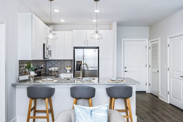 Modern kitchen with stainless steel appliances at The Grove at Coastal Grand Apartments, a luxury Greystar community