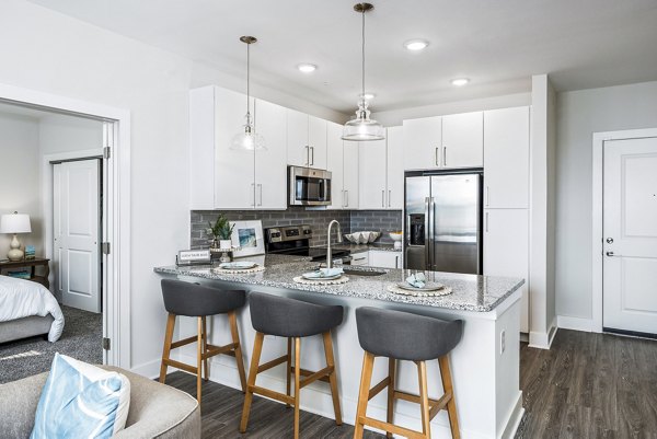 Modern kitchen with stainless steel appliances at The Grove at Coastal Grand Apartments