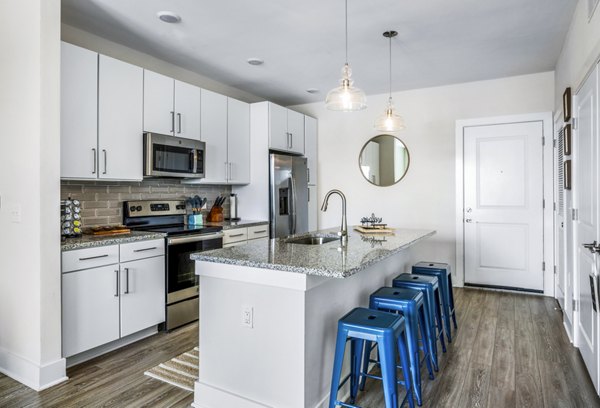 The Grove at Coastal Grand: Modern kitchen with stainless steel appliances and granite countertops in luxury apartments