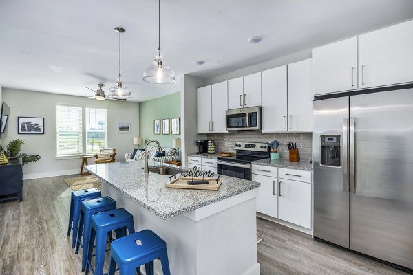 Modern kitchen featuring sleek countertops and stainless steel appliances at The Grove at Coastal Grand Apartments