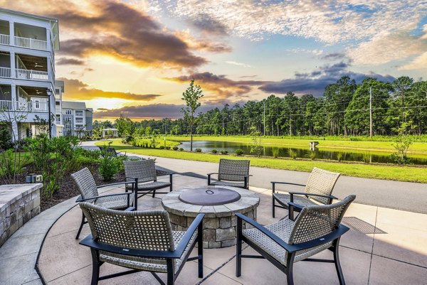 The Grove at Coastal Grand Apartments: Cozy outdoor patio with fire pit for luxury living