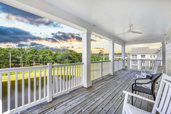 Spacious clubhouse patio with modern furniture at The Grove at Coastal Grand Apartments, perfect for socializing and relaxation