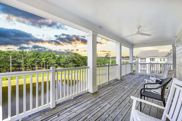 Spacious clubhouse patio with modern furniture at The Grove at Coastal Grand Apartments, perfect for socializing and relaxation