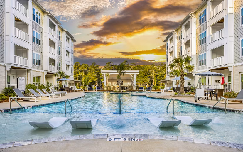 Luxurious pool at The Grove at Coastal Grand Apartments with relaxing lounge areas, perfect for residents seeking premium amenities and comfort