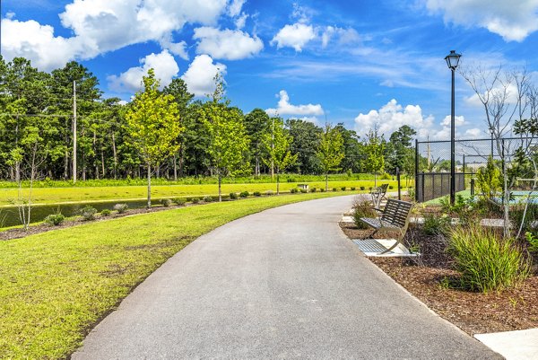 Running trail surrounded by lush greenery at The Grove at Coastal Grand Apartments, offering outdoor fitness and leisure opportunities