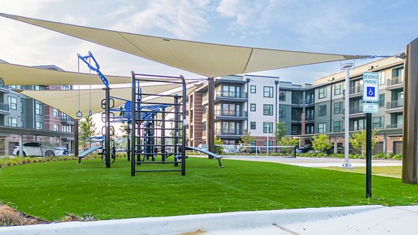 Starling at Bridgeland Apartments: Modern playground with slides and swings for family fun