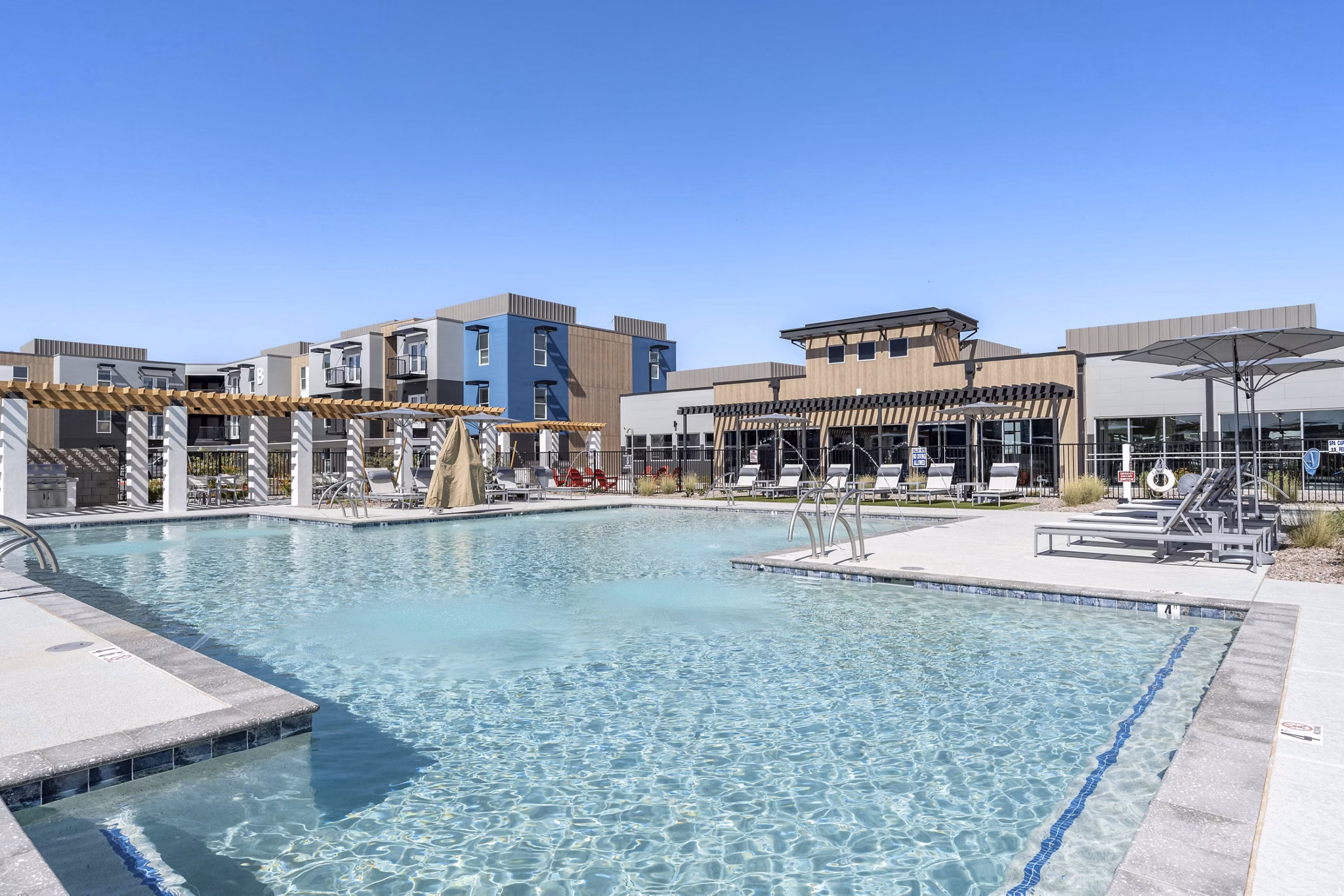 Resort-style pool with lounge chairs at FLATZ 520 Apartments in scenic location