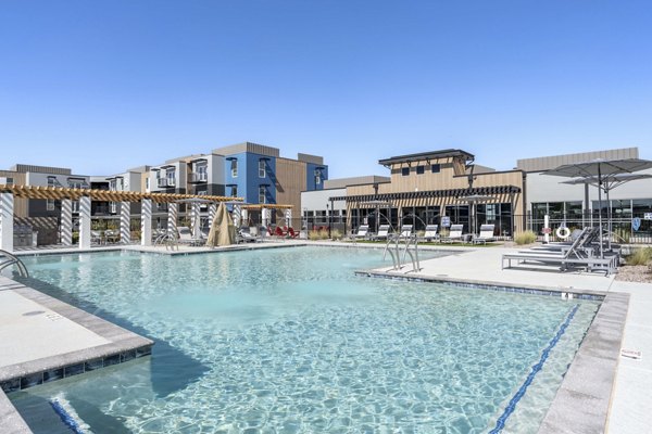 Resort-style pool with lounge chairs at FLATZ 520 Apartments in scenic location