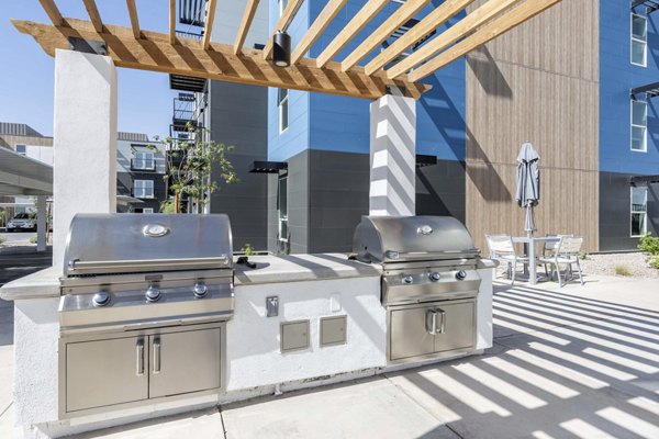 Outdoor grill area with modern seating at FLATZ 520 Apartments, perfect for social gatherings and cookouts