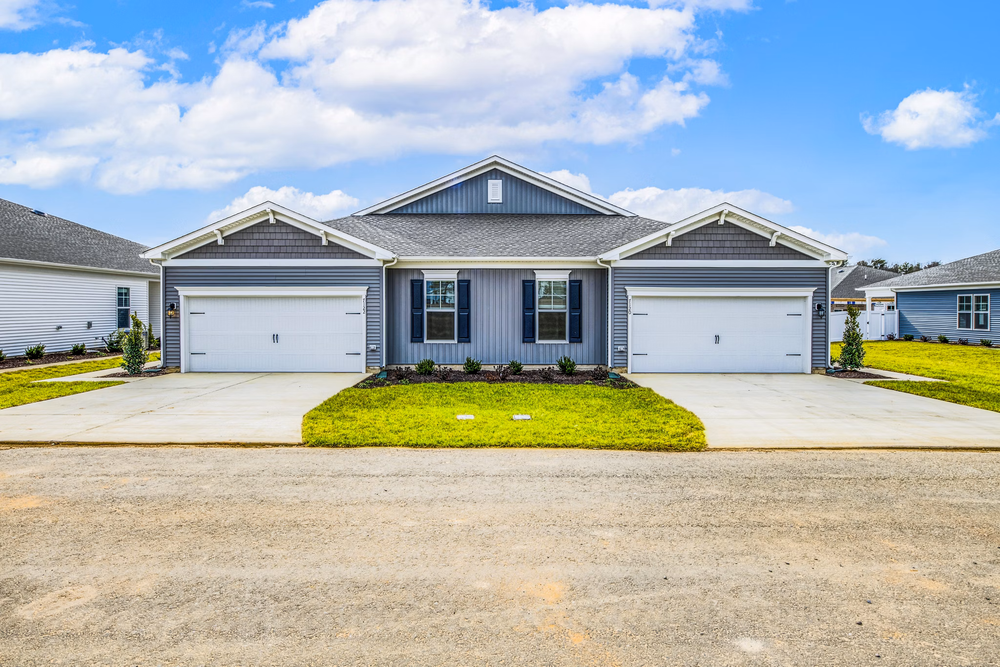Duplex house with two garages and a shared driveway in a residential neighborhood