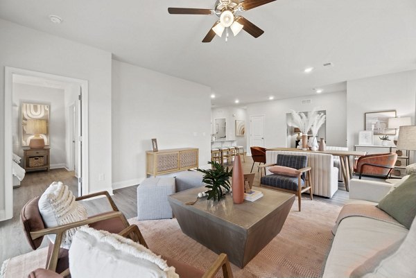 Living room with cozy seating and natural light at Maple Grove Apartments, offering a luxury rental experience for discerning residents