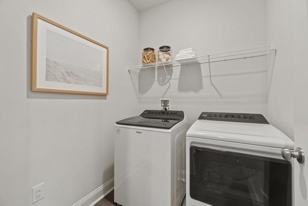 Laundry room featuring modern washers and dryers in Maple Grove Apartments