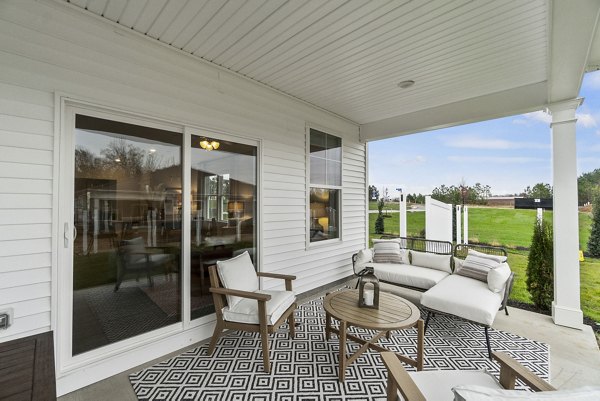Maple Grove Apartments: Relaxing outdoor patio with modern seating and lush greenery