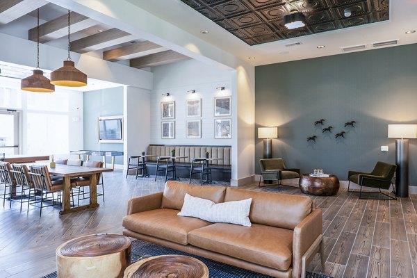 Clubhouse lobby with modern furnishings and wood accents at Birchway Hudson Oaks Apartments