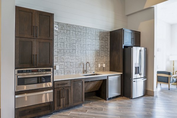 Modern clubhouse kitchen with stainless steel appliances at Birchway Hudson Oaks Apartments