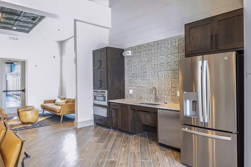 Clubhouse kitchen featuring modern appliances and island seating at Birchway Hudson Oaks Apartments