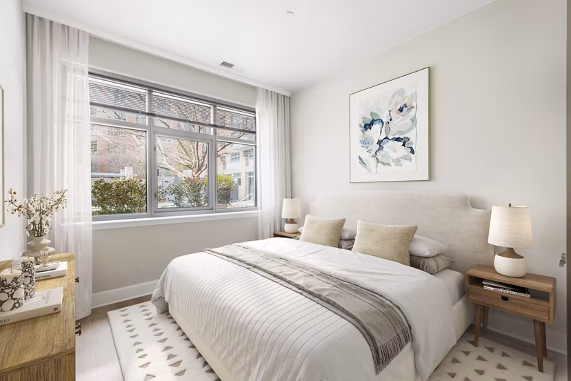 Cozy bedroom with plush bedding and modern decor at The Avant at Reston Town Center Apartments