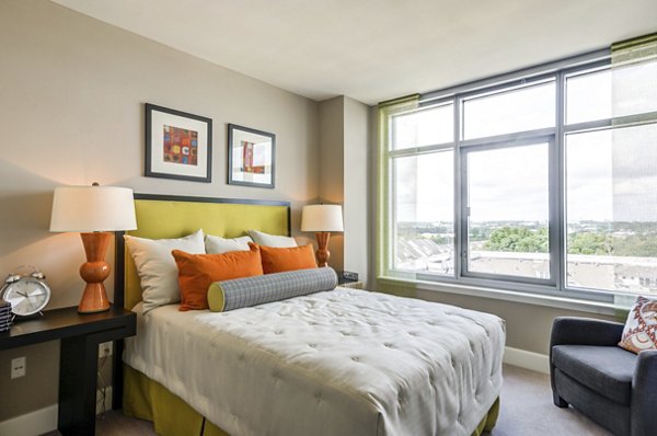Cozy bedroom with plush bedding and modern decor at The Avant at Reston Town Center Apartments
