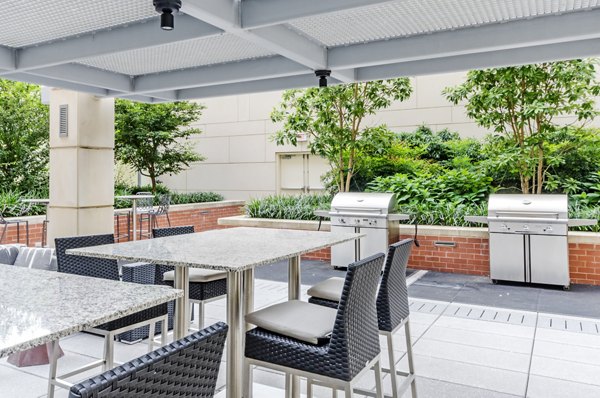 Outdoor grill area with modern seating at The Avant at Reston Town Center Apartments, offering a perfect space for community gatherings and dining