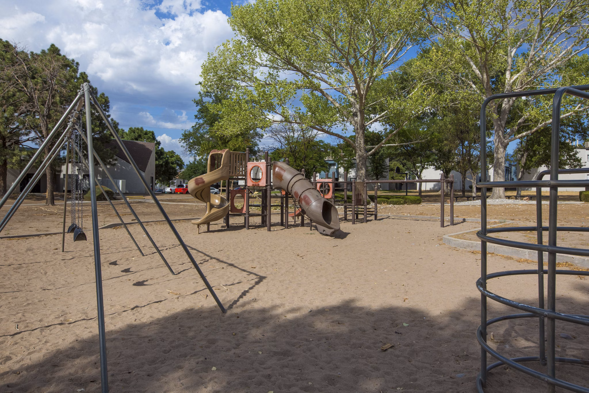Playground at Sun Plaza Apartments: Modern play area with swings and slides in the Sun Plaza Apartments community