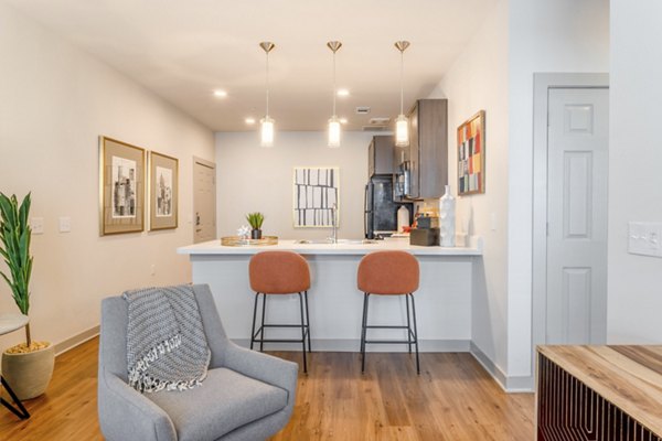 Bright living room with modern furnishings in Espria Apartments, ideal for relaxation and entertainment