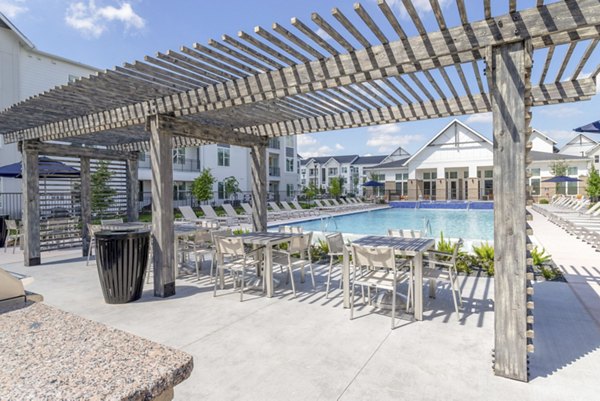 Outdoor recreation area with lush greenery and seating at Espria Apartments